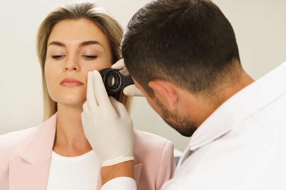 woman having mole check with dermatoscope